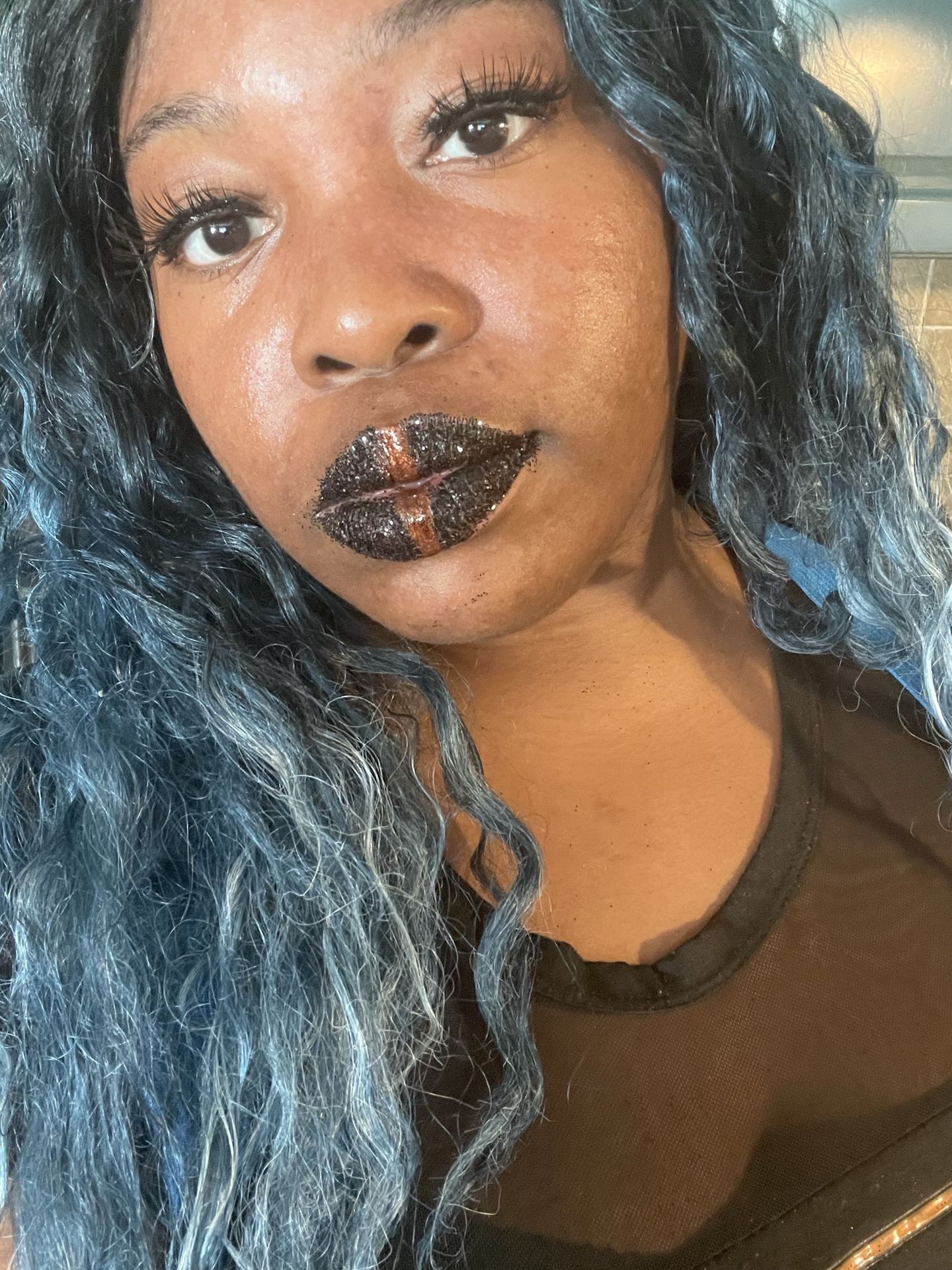 Woman with charcoal curls and matte obsidian-black lip color