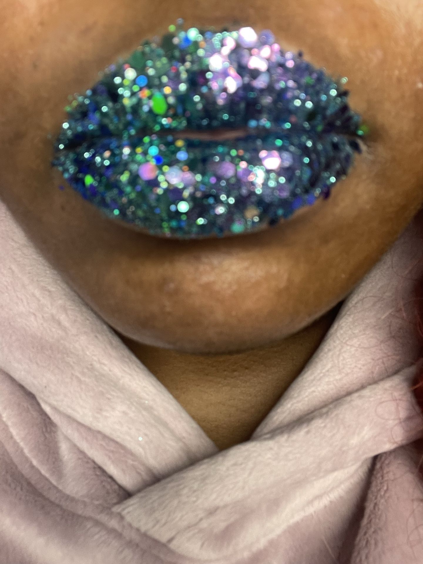 Close-up of deep blue and green glitter mosaic lipstick