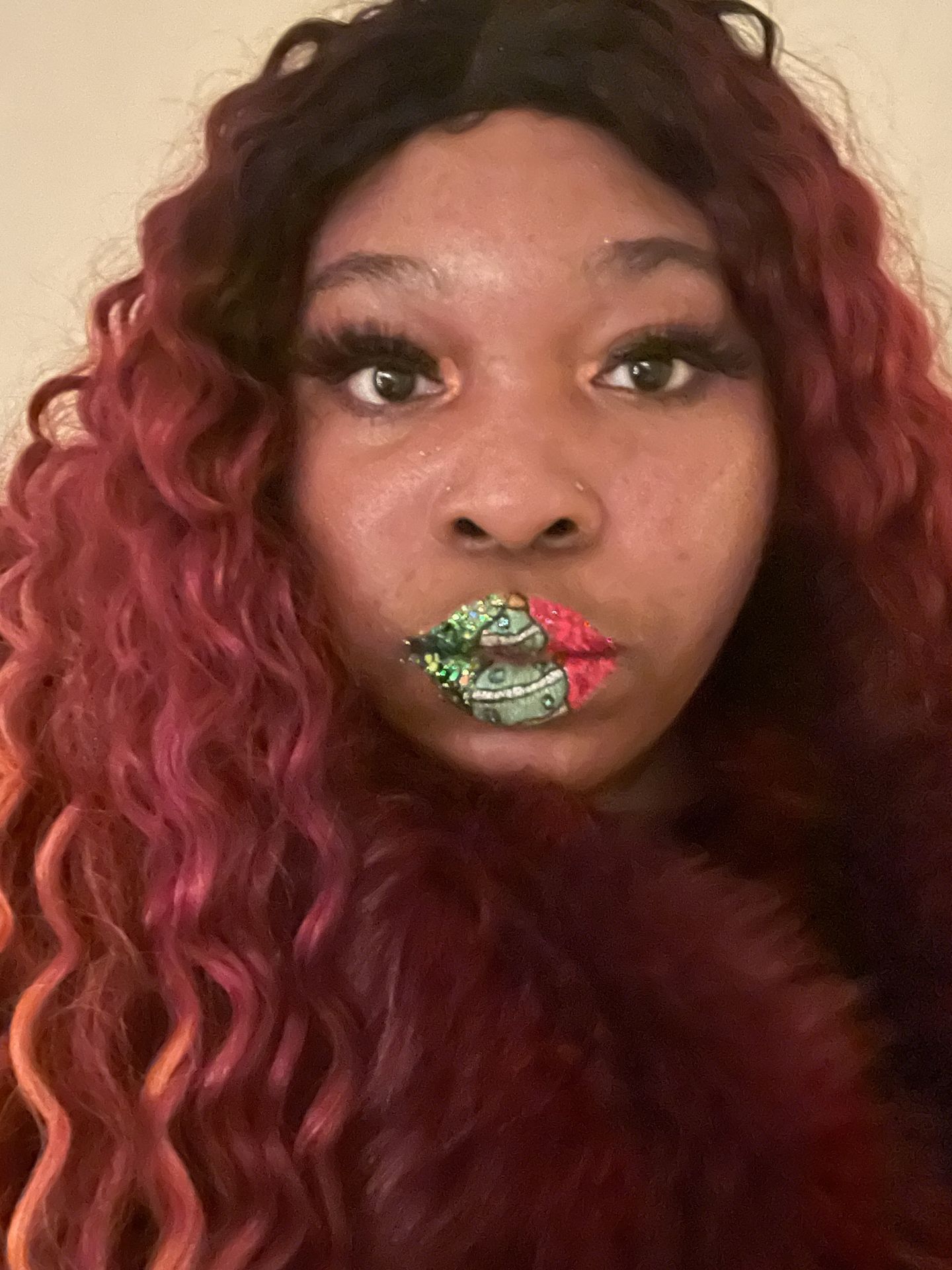Woman with auburn curls wearing green crystal lip accents