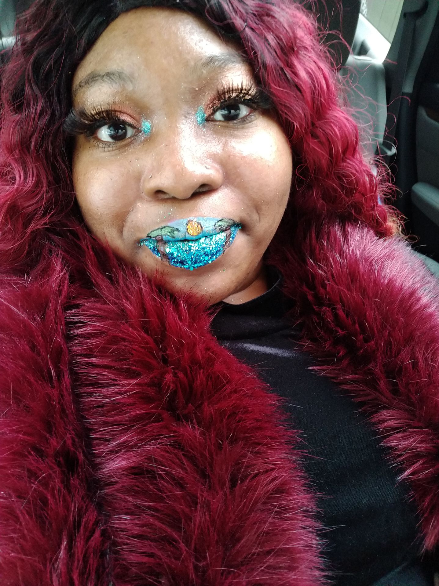 Black woman with gold glitter lipstick and warm copper hair