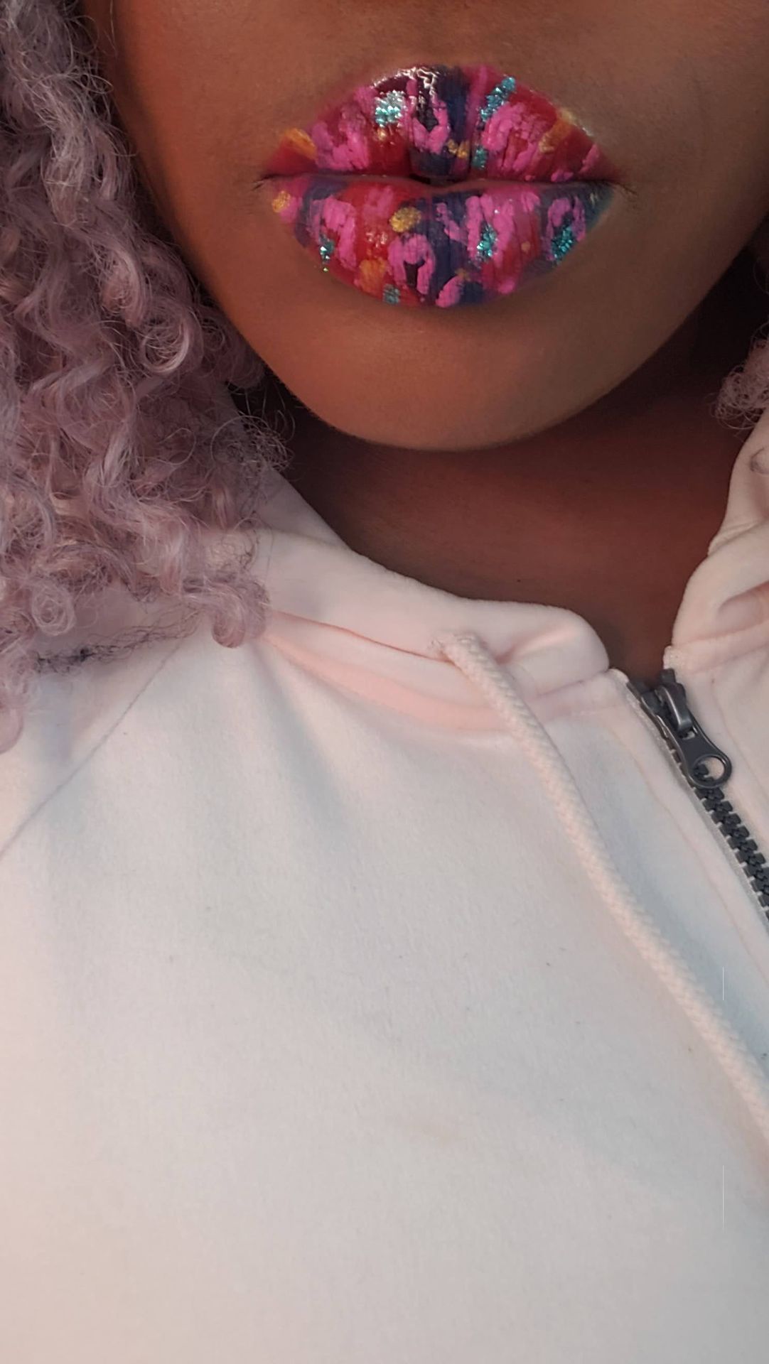Close-up of soft pink sweater with neutral glossy lips