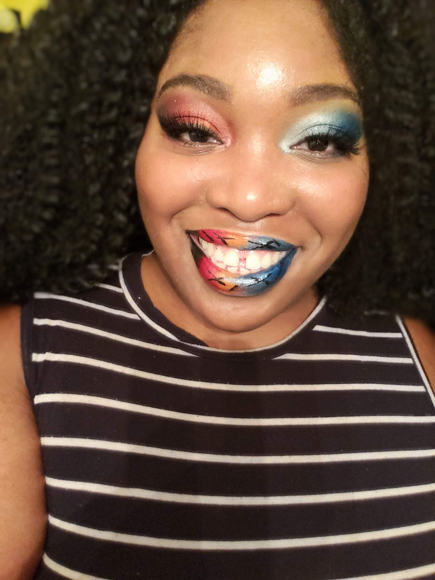 Black woman with short natural hair wearing multicolor glitter lips