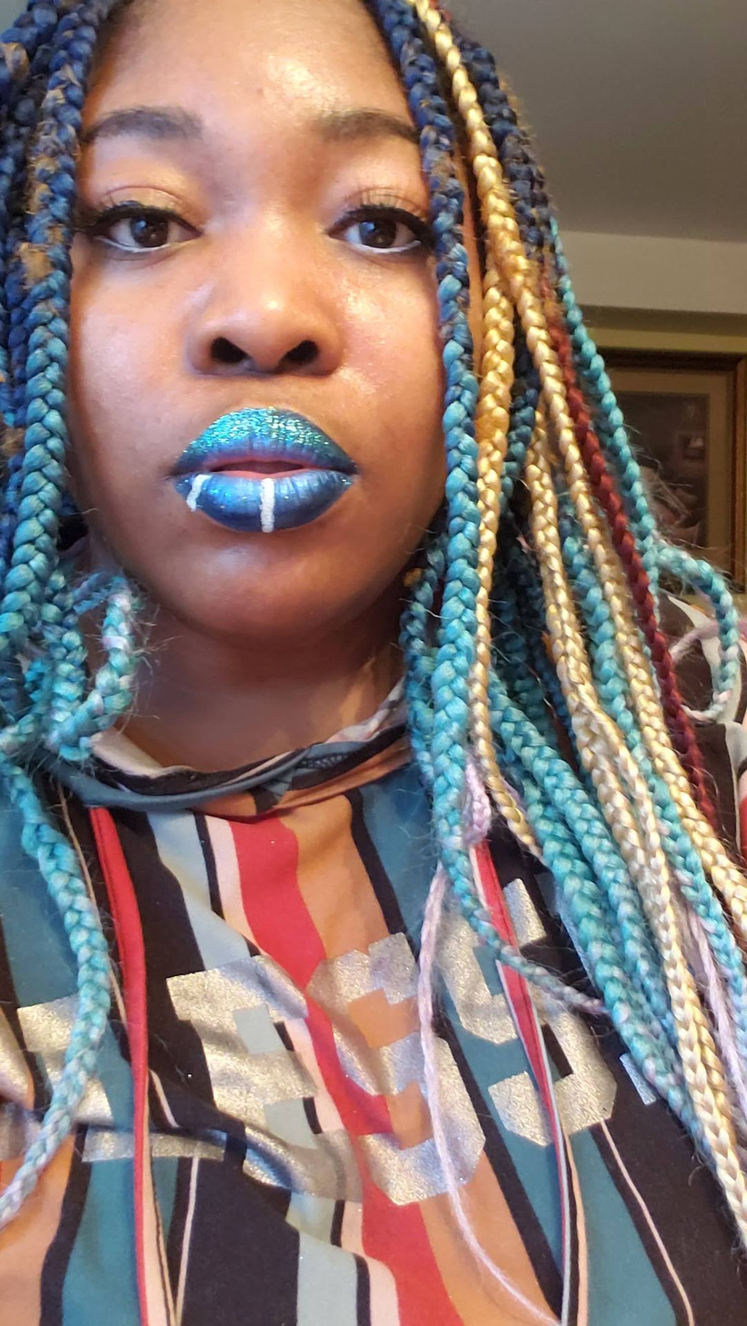 Woman with multicolored braids wearing vivid blue metallic lipstick