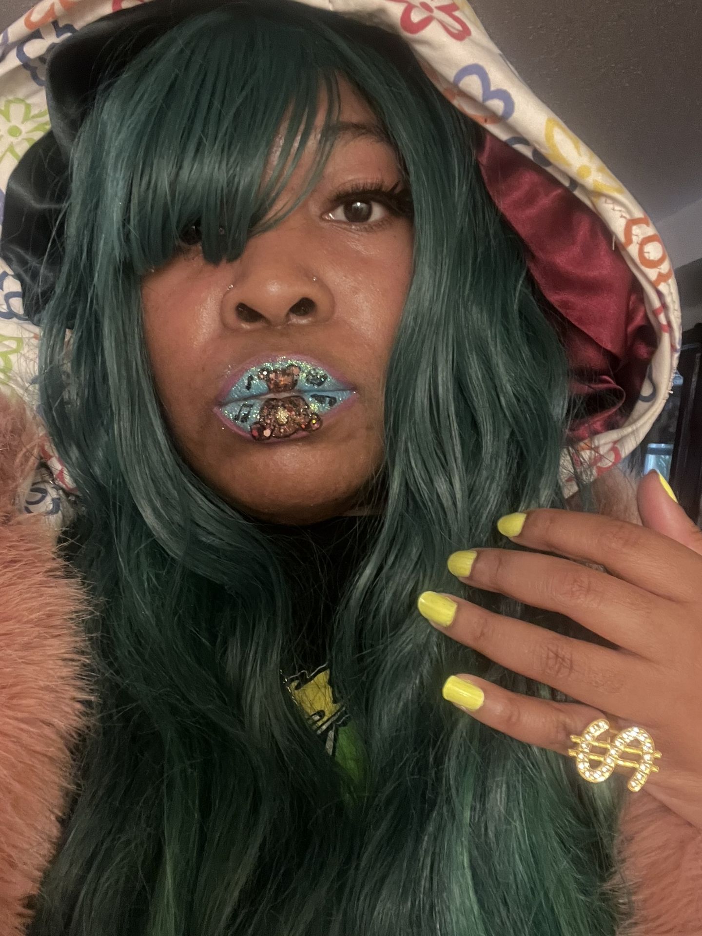 Woman with dark hair and emerald rhinestone lip detailing