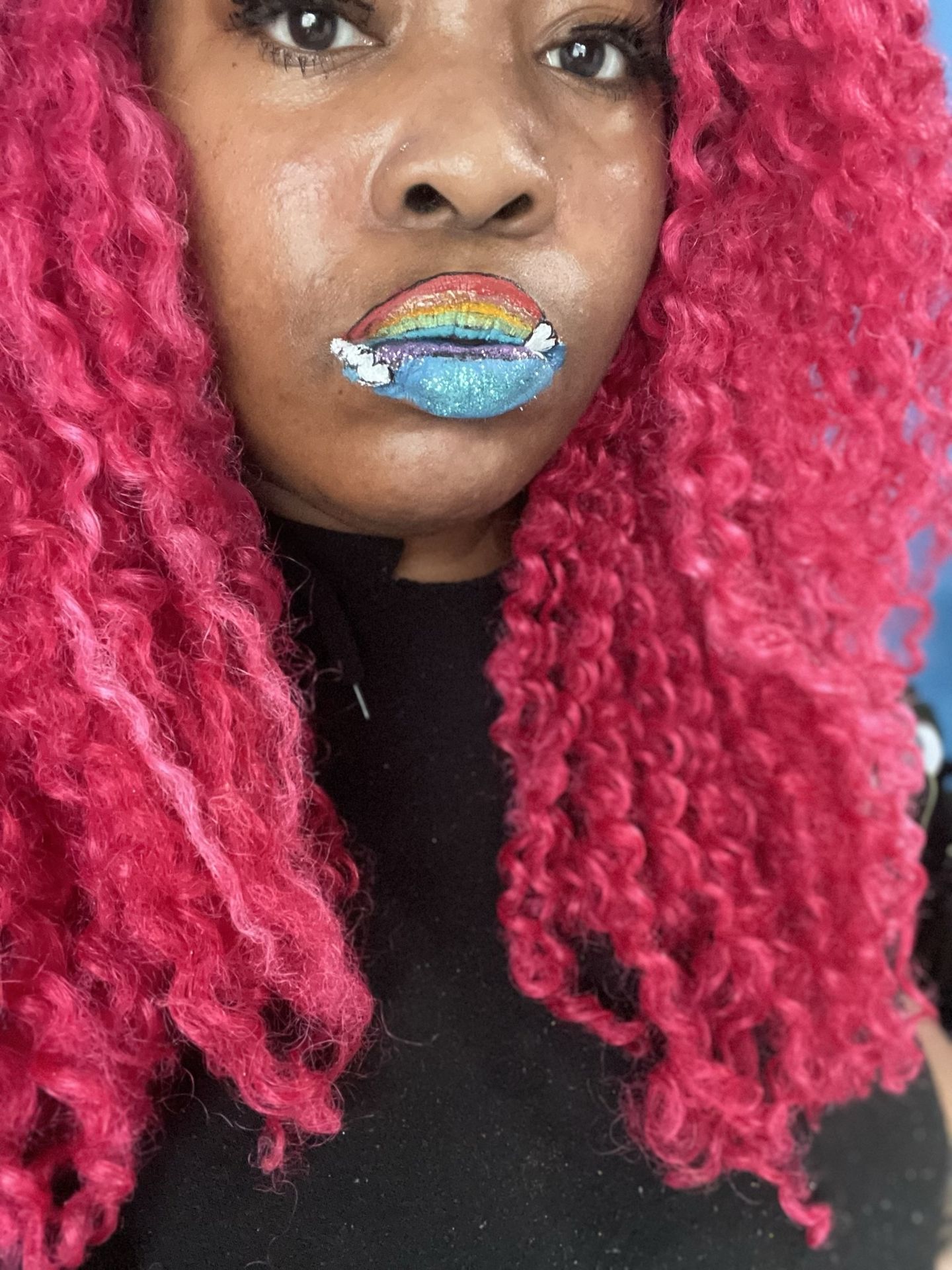 Woman with hot-pink curls wearing silver-blue glitter lipstick