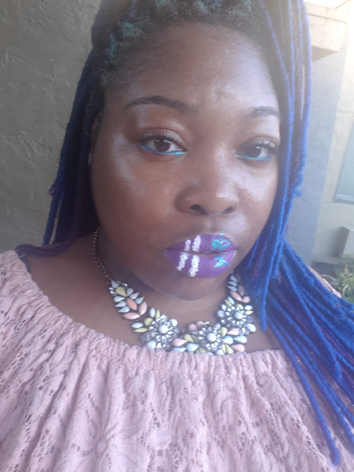 Woman with straight black hair wearing icy blue rhinestone lips