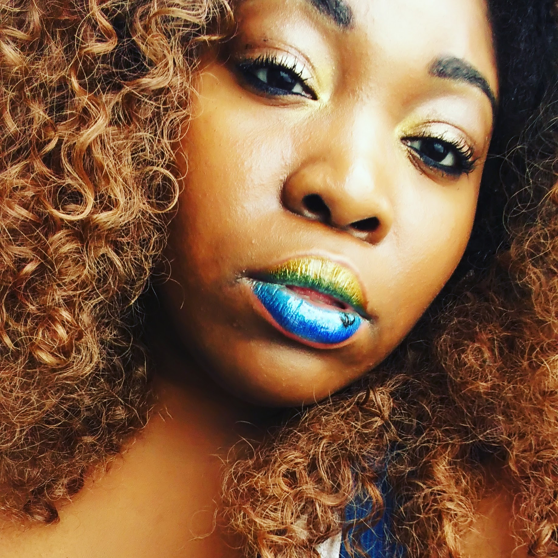 Woman with golden curls and matte teal-blue lipstick