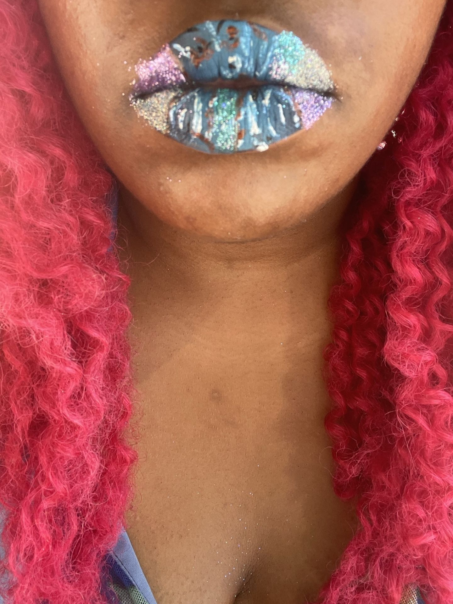 Close-up of holographic silver glitter lips framed by pink hair
