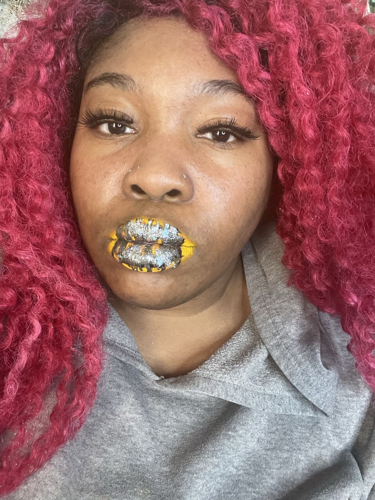 Woman with burgundy waves and brushed gold foil lip art