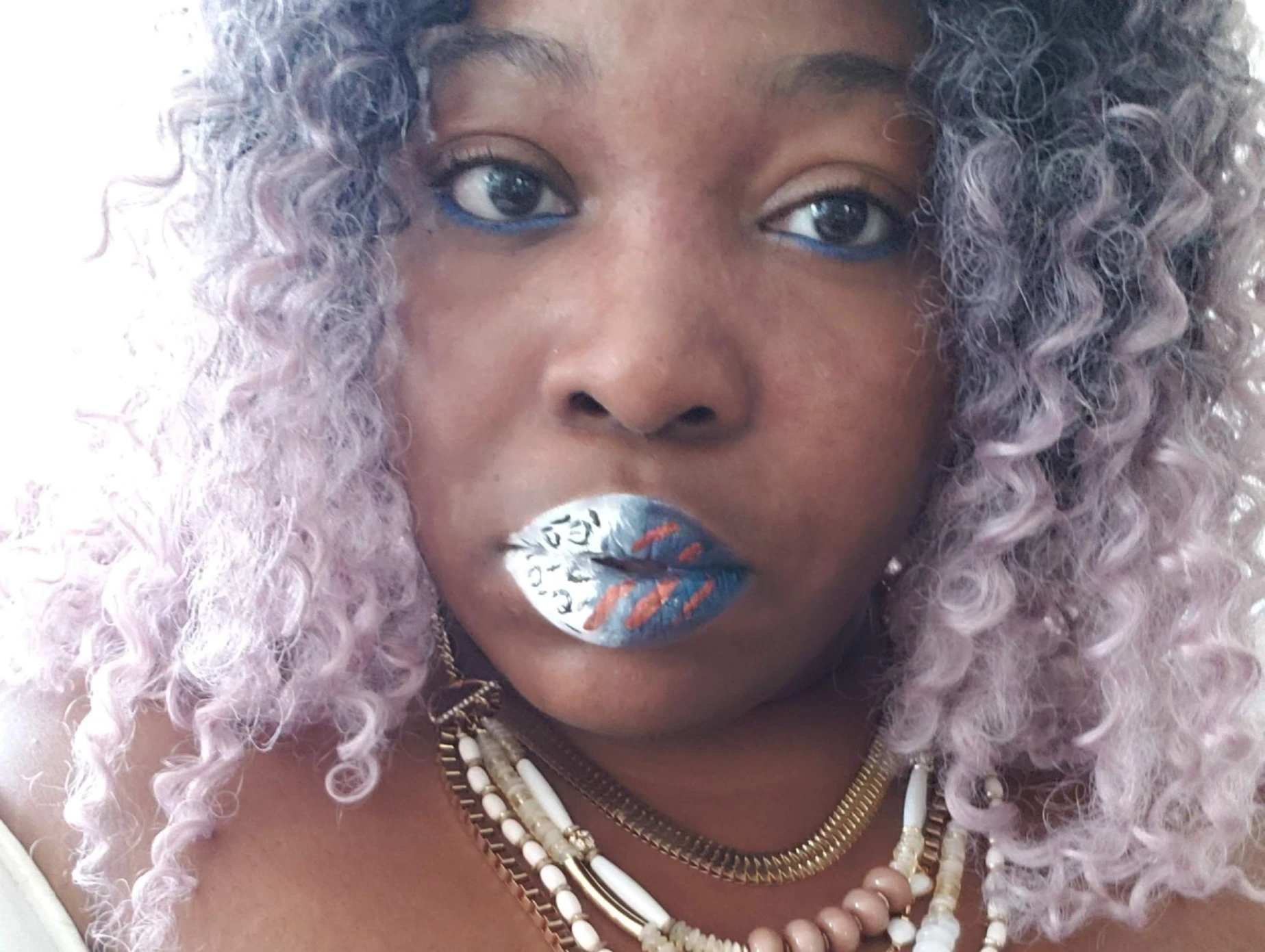 Woman with silver curls wearing metallic sapphire lipstick