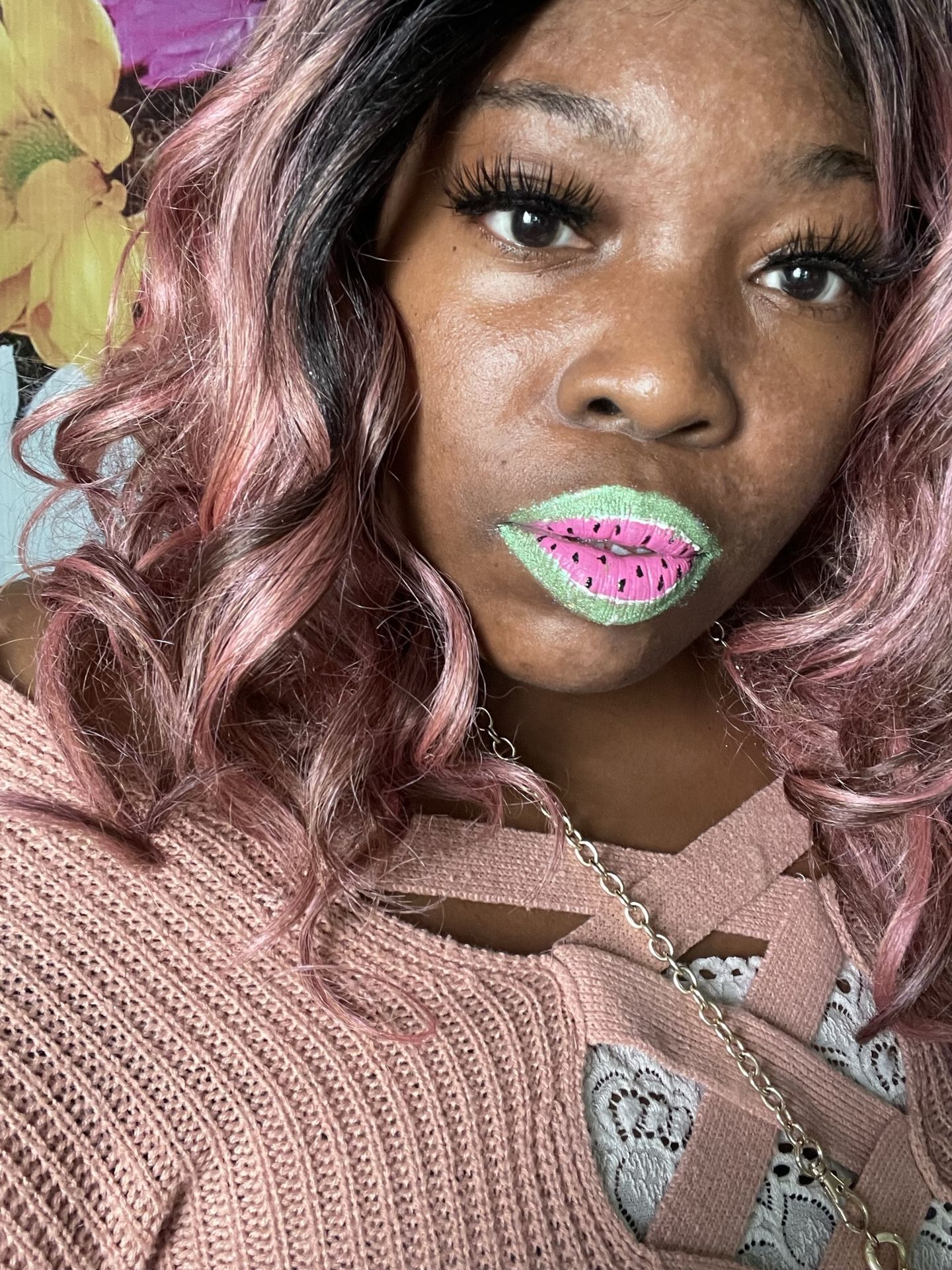 Black woman with rose-gold curly hair and green crystal lip accents