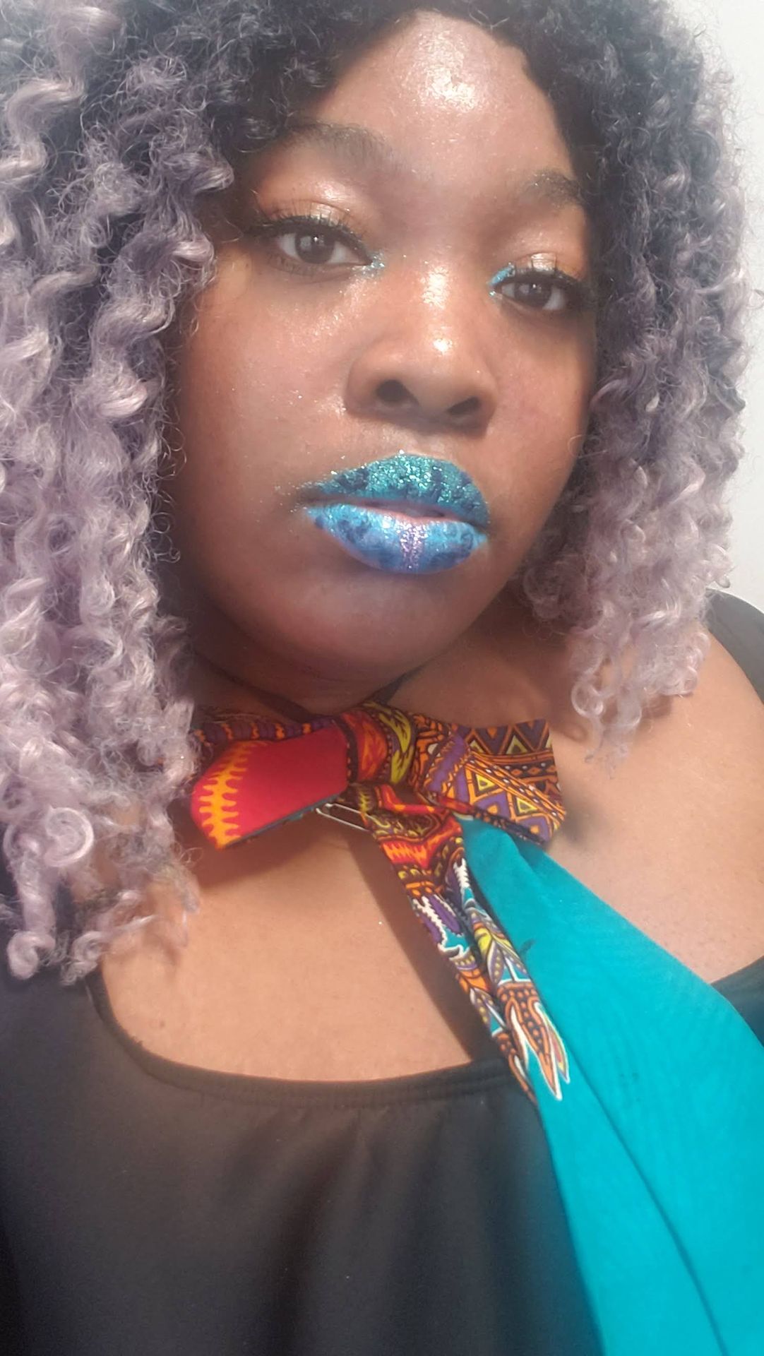 Woman with lavender hair wearing bright aqua shimmer lipstick