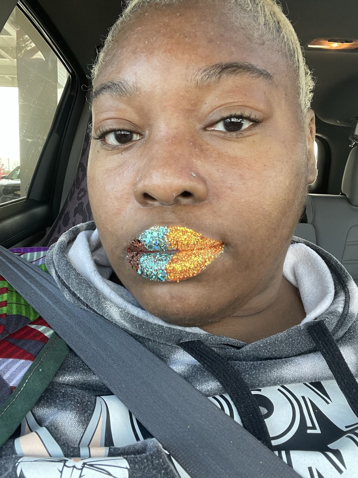 Woman with short hair wearing mustard and silver foil lip design