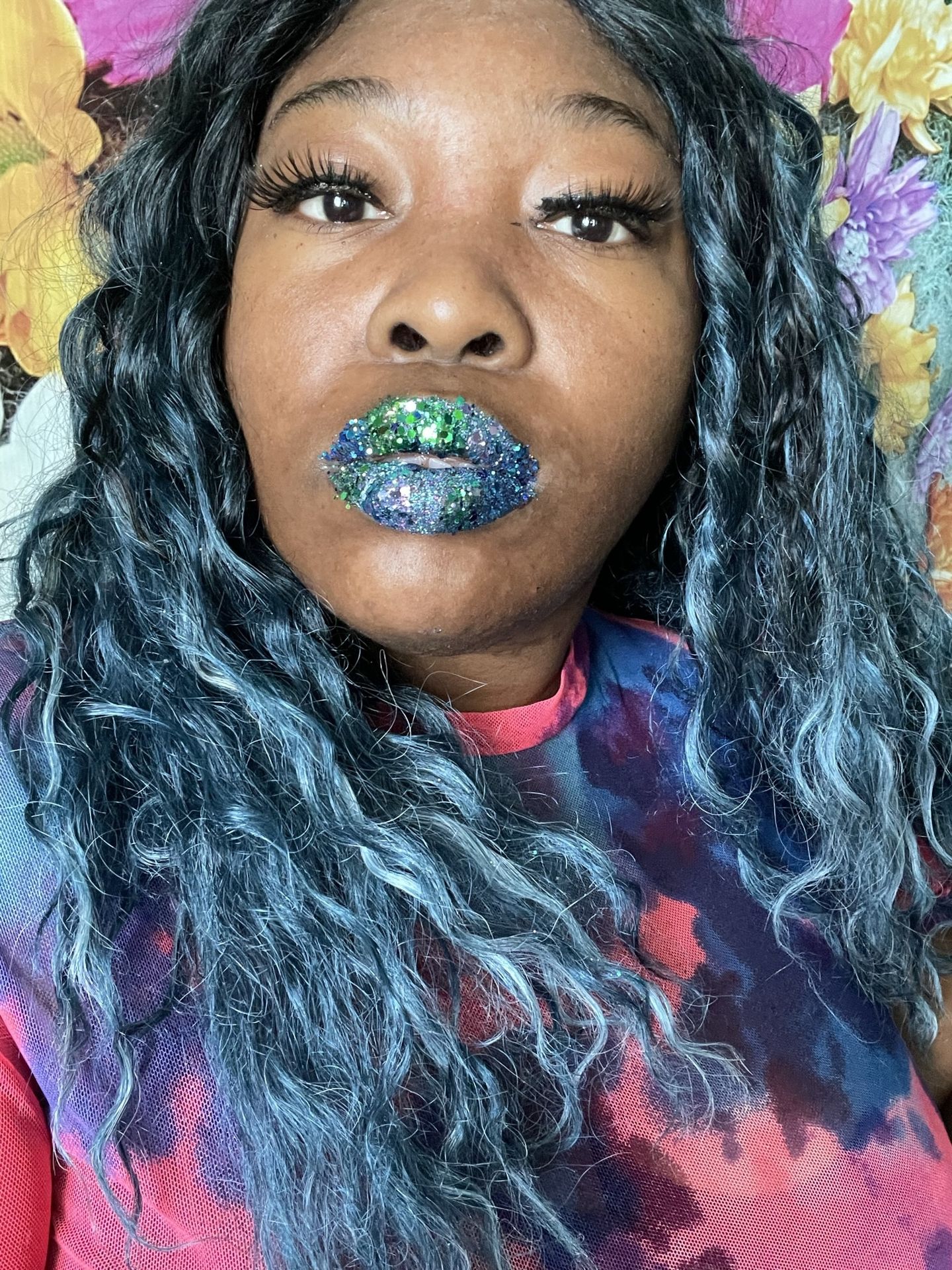 Woman with blue-black waves wearing sapphire glitter lipstick