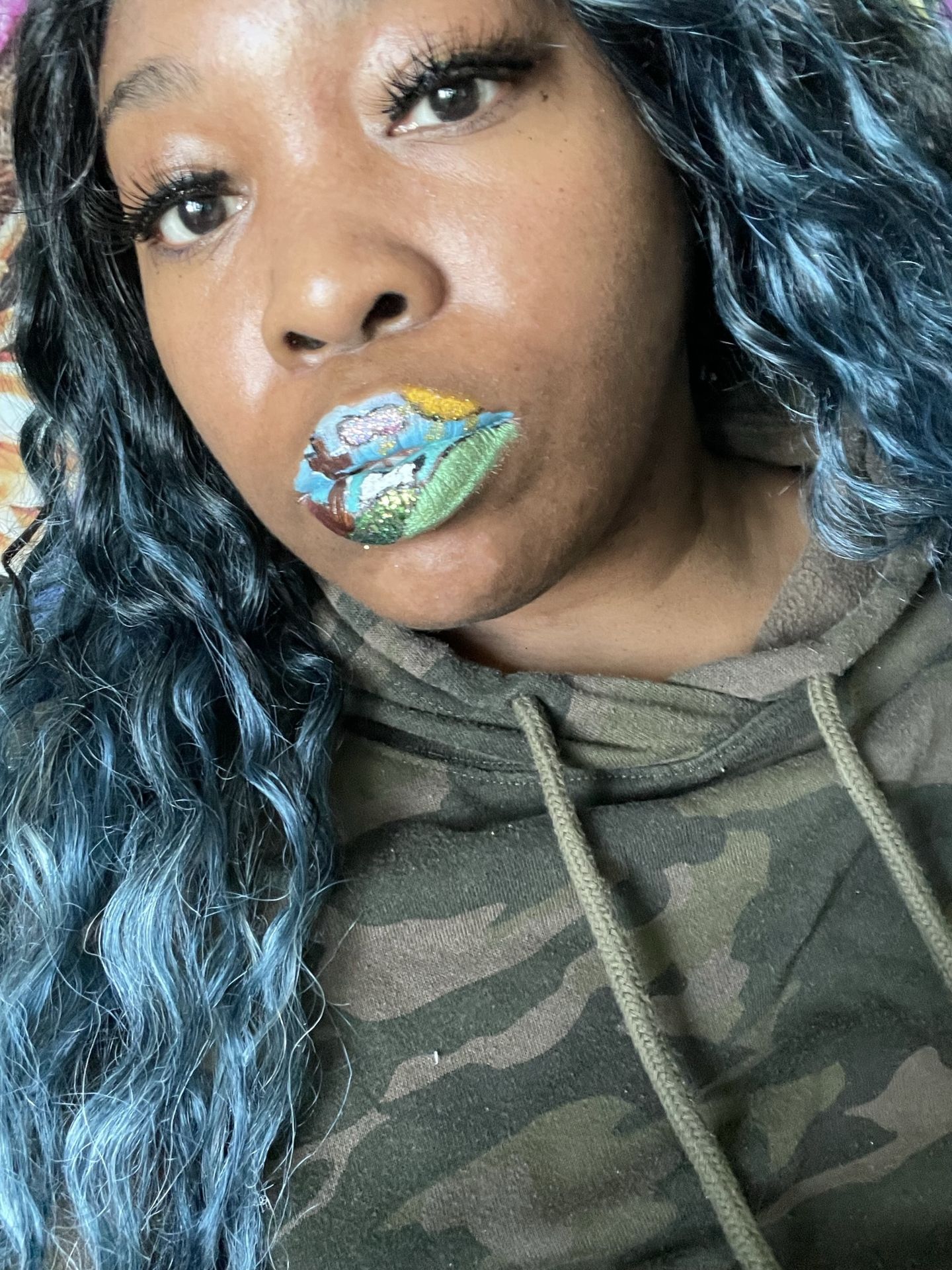 Woman with teal curls and emerald rhinestone lip design