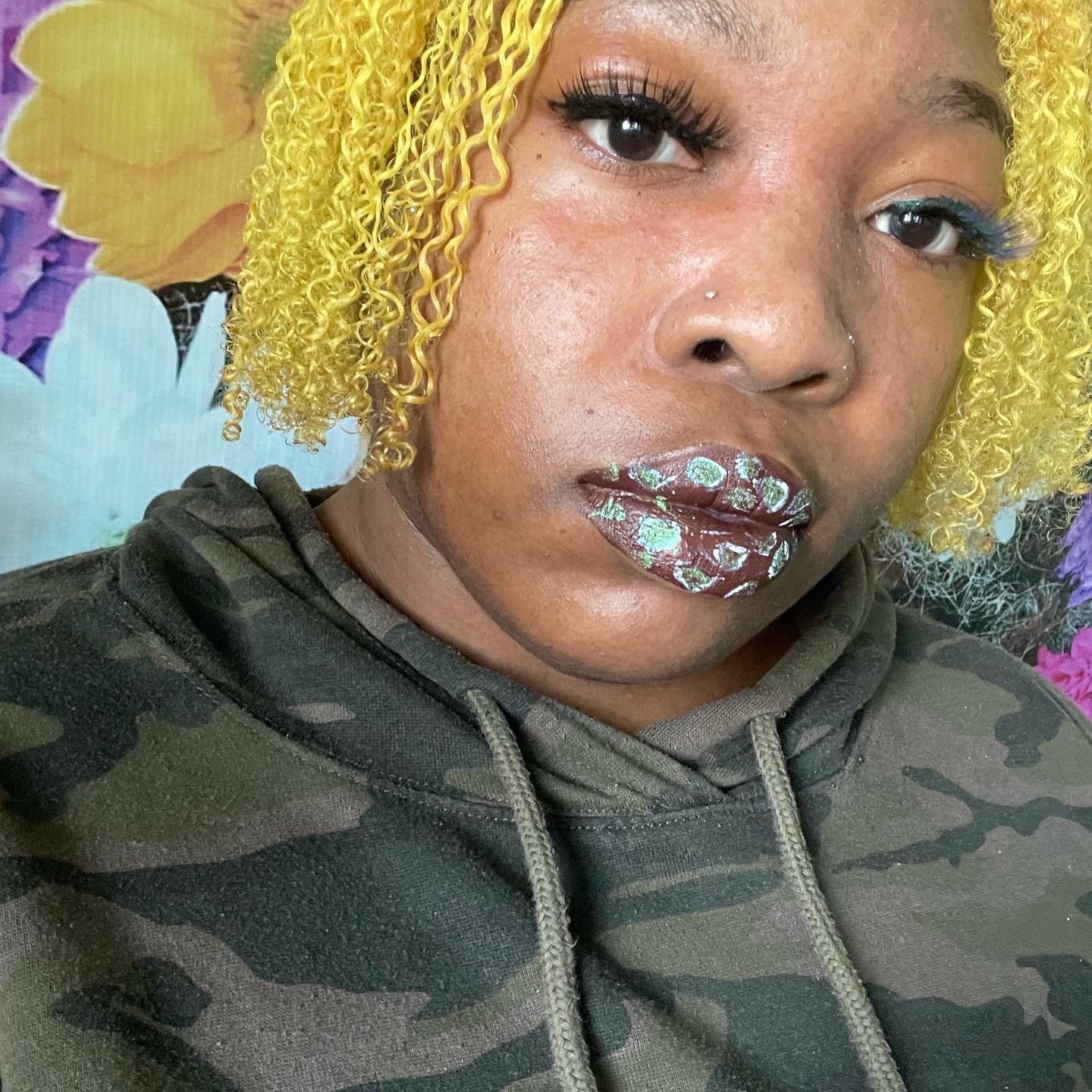 Woman with short yellow curls wearing soft blue satin lipstick