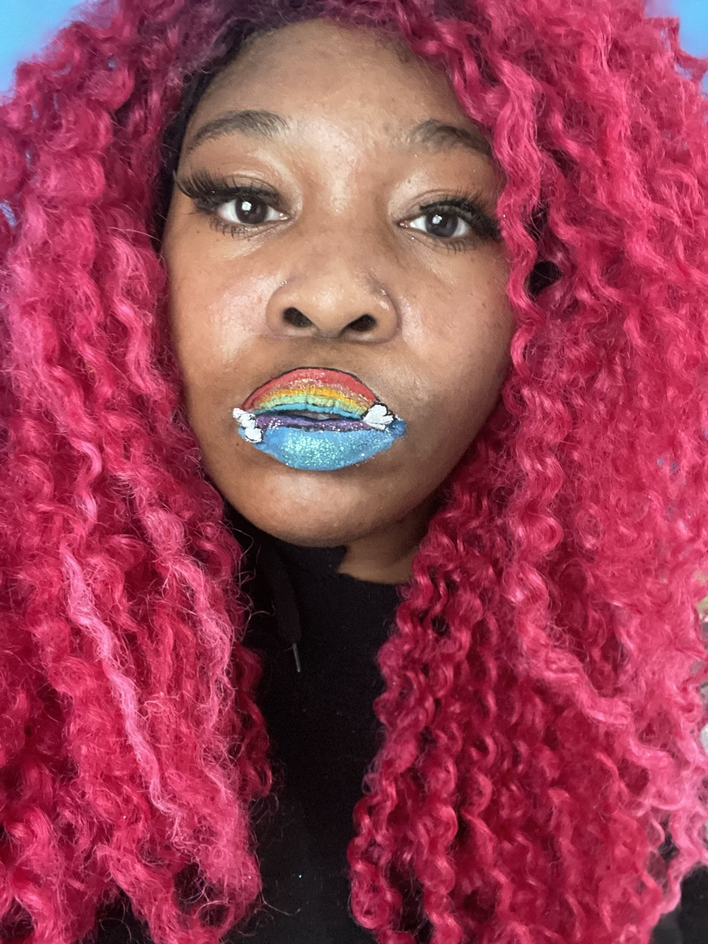 Black woman with dark curls and iridescent rainbow glitter lips, high-contrast creative portrait.