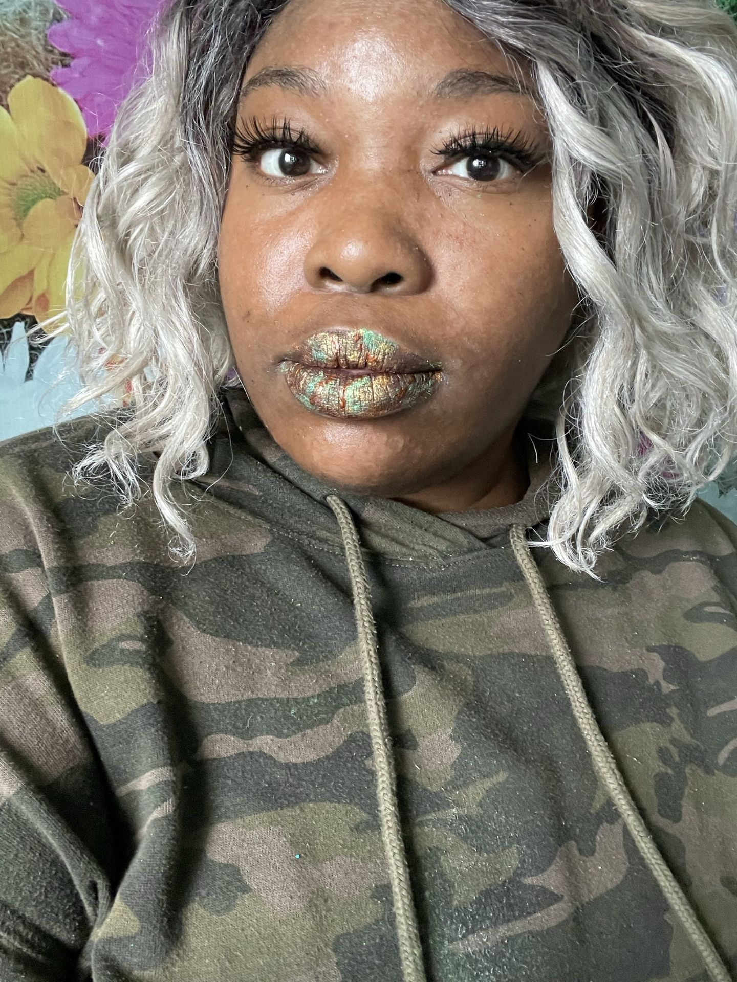 Black woman with dark curls and silver crystal lip detailing