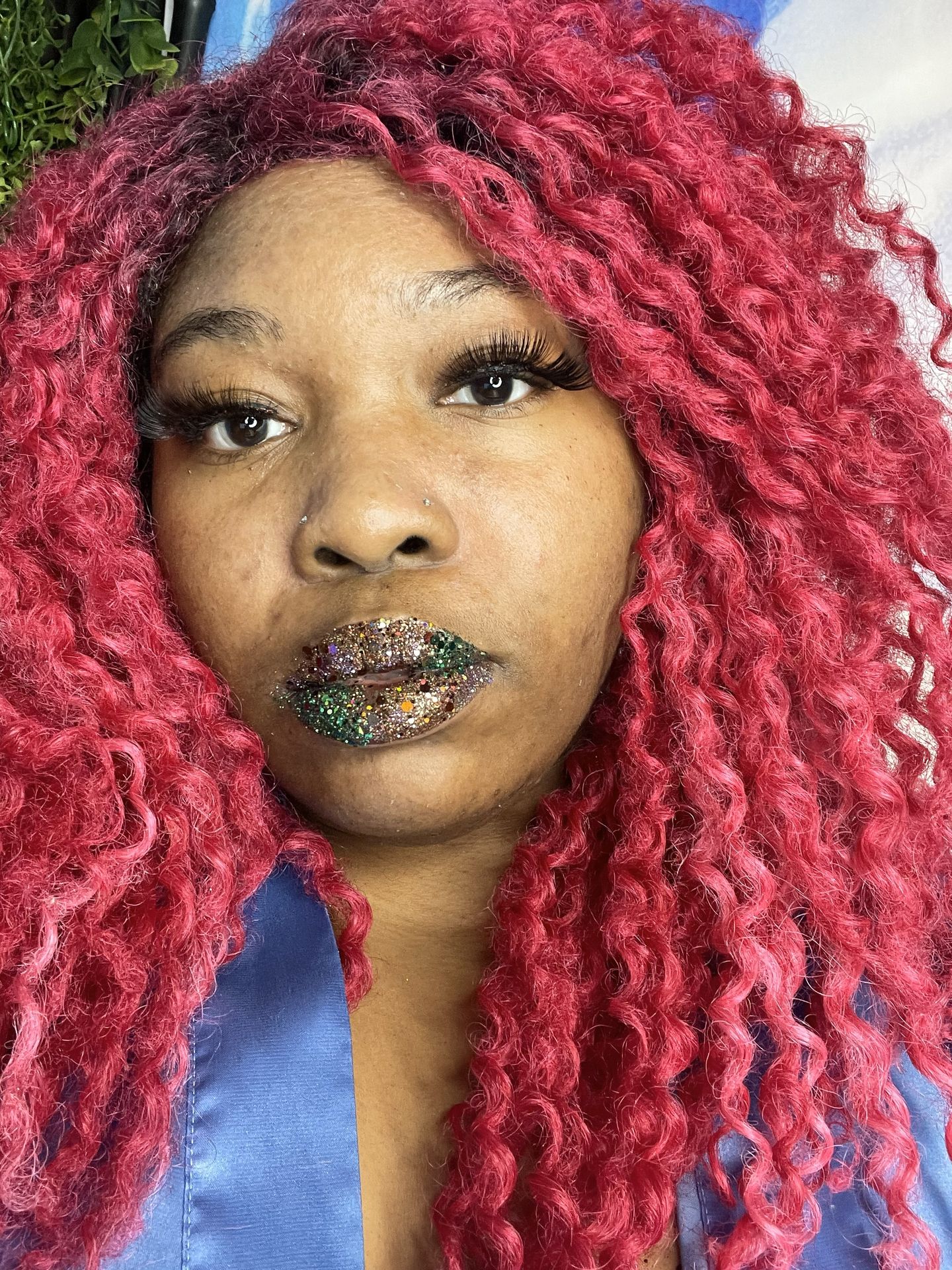 Black woman with red hair and galaxy-style glitter lips, cosmic-inspired artistic makeup portrait.