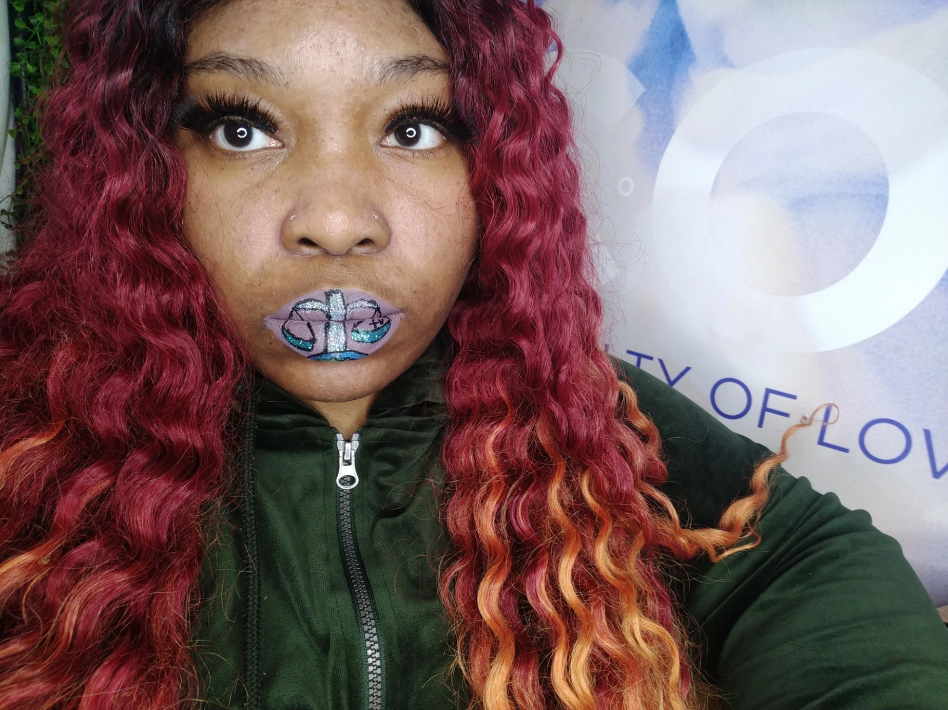 Black woman with auburn ombré curls and blue gemstone lip art