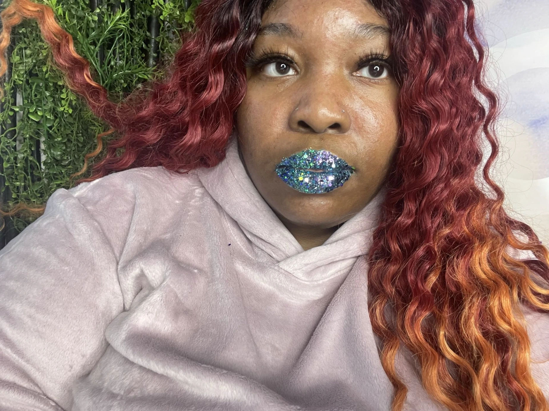 Woman with copper curls wearing icy blue satin lipstick