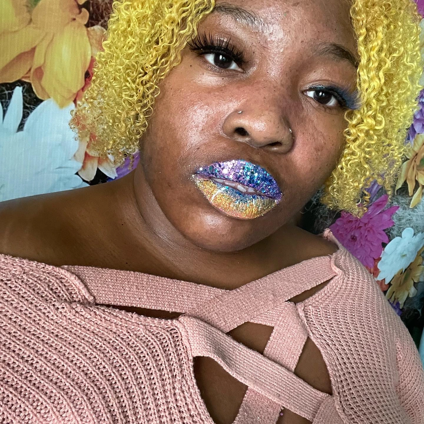 Woman with yellow curls wearing cool-toned blue gloss