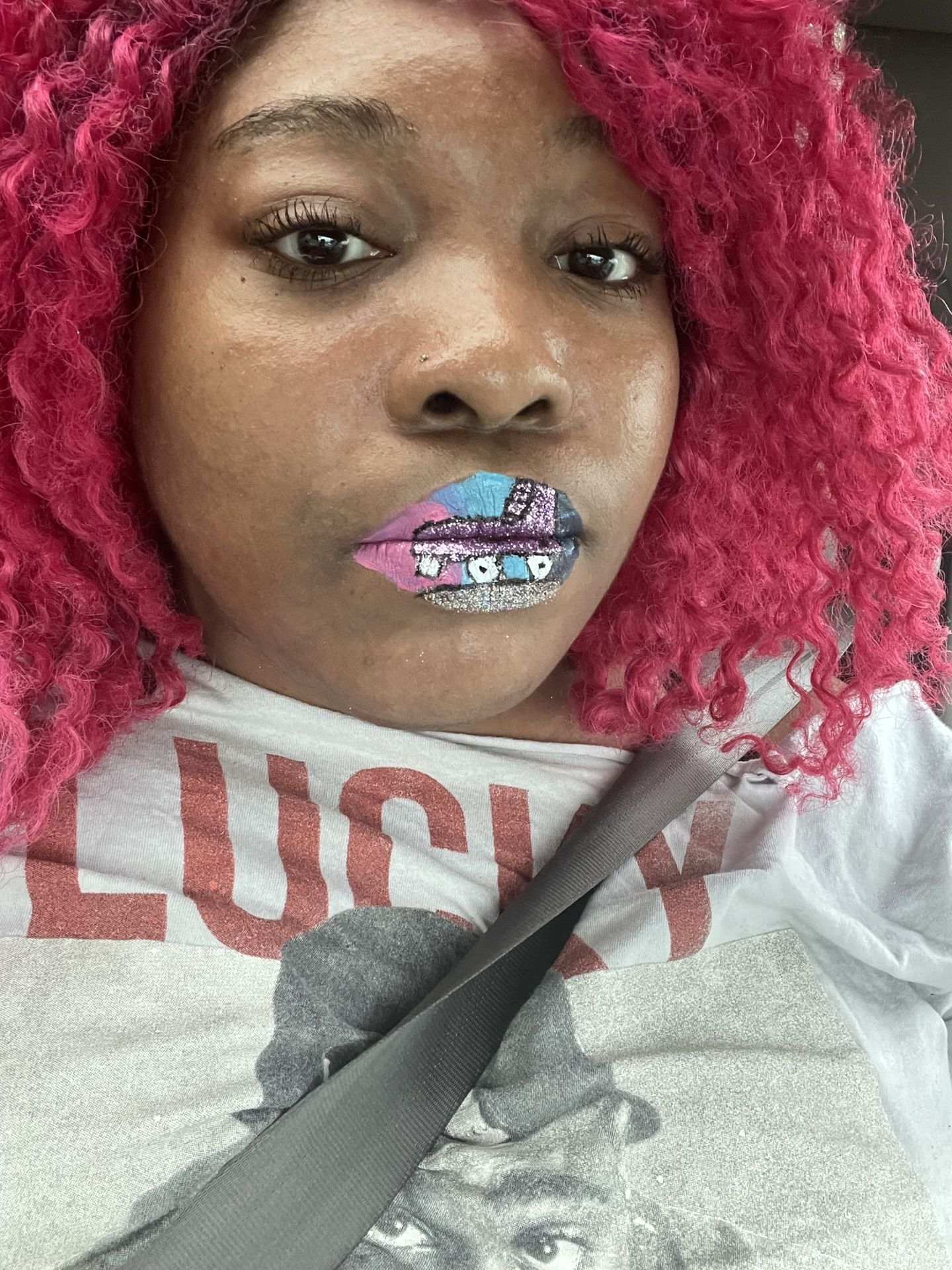 Black woman with pink curls wearing silver glitter lipstick
