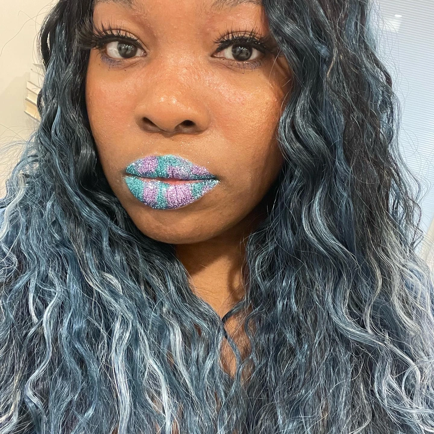 Woman with silver-blue hair wearing matte turquoise lipstick