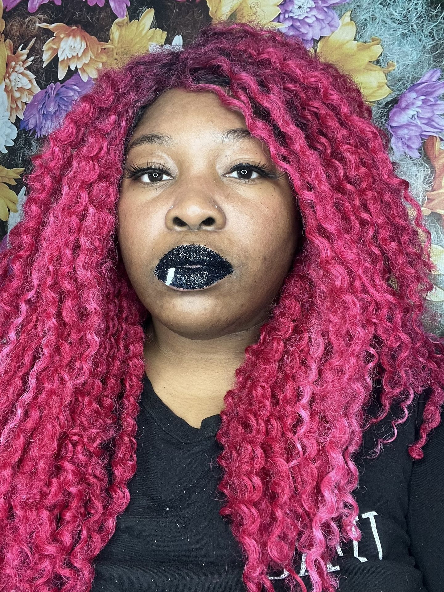 Woman with crimson curls wearing matte midnight-blue lipstick