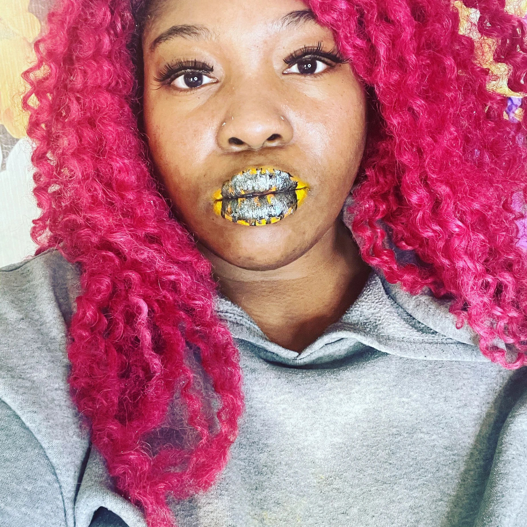 Woman with hot pink curls wearing olive-green shimmer lips